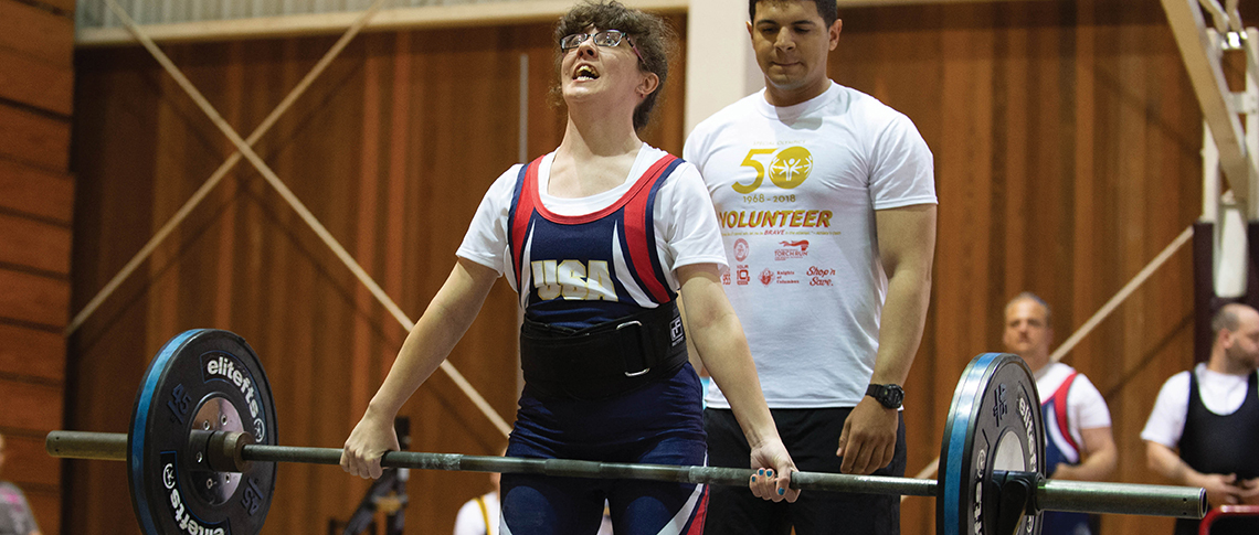 Female athlete grimacing while lifting heavy weights during a competition